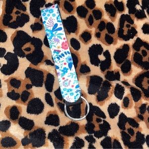 This a a keychain with a white base and colorful flowers.